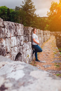 Rear view of boy standing on stone wall