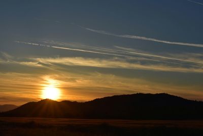 Scenic view of silhouette mountains against sky during sunset