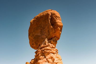 Low angle view of rocks against blue sky