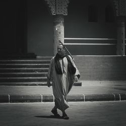 Rear view of woman standing against building