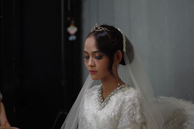 Bride sitting against wall