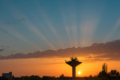 Silhouette of building against cloudy sky during sunset