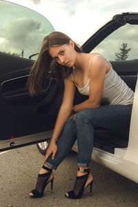 Full length of woman sitting in park against sky