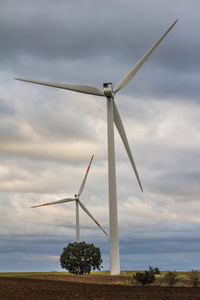 Wind turbine against cloudy sky