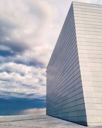 Low angle view of modern building against cloudy sky