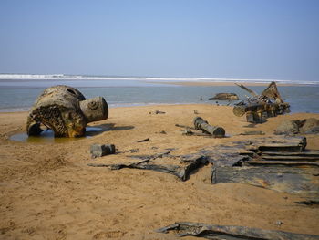 Rocks on beach against clear sky