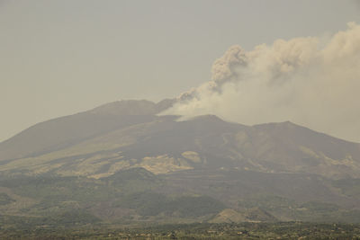 Smoke emitting from volcanic mountain against sky