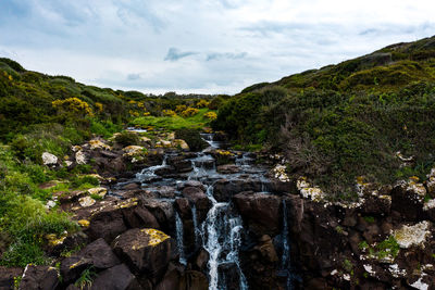 Scenic view of waterfall against sky