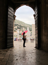 Full length of woman standing amidst buildings in city