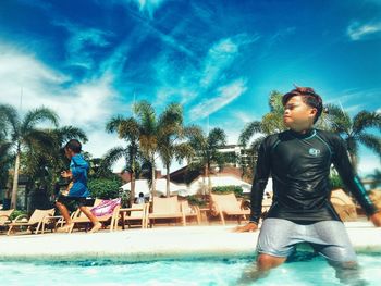 Full length of children in swimming pool against sky