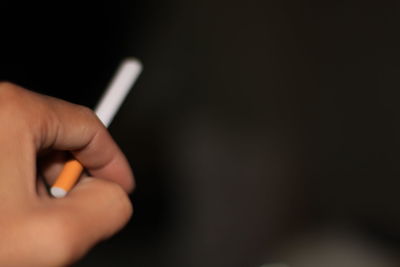 Close-up of hand holding cigarette