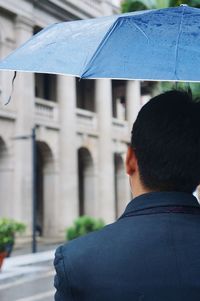 Rear view of man against built structure