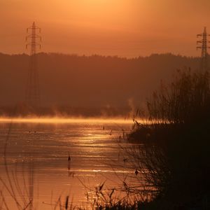 Scenic view of lake against sky during sunset