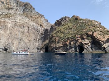 Scenic view of rocks in sea against clear sky