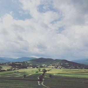 Scenic view of field against cloudy sky