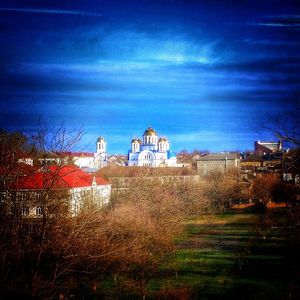 Houses on field against cloudy sky