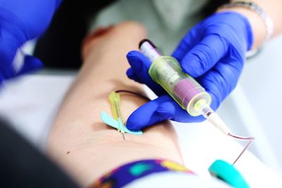 Cropped image of doctor giving iv drip to patient in hospital