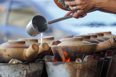 Man pouring water into claypot to cook the dish