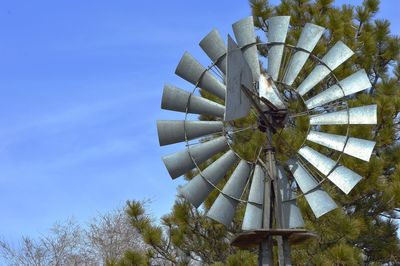 Low angle view of windmill against blue sky