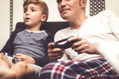 Father and son playing video game at home