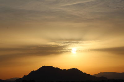 Scenic view of silhouette mountains against romantic sky at sunset