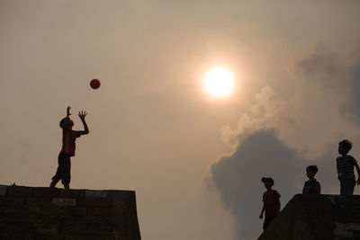 Low angle view of silhouette man standing against sky