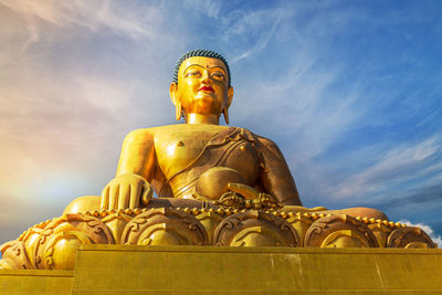 Low angle view of statue against temple against sky