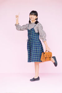 Portrait of smiling girl standing against white background