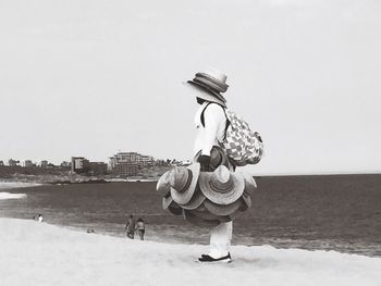 Boy on beach against clear sky