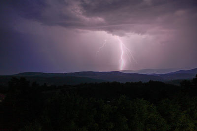 Scenic view of lightning over mountains