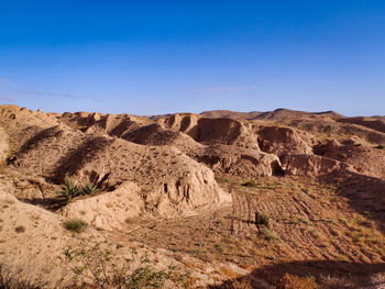 Scenic view of desert against clear blue sky