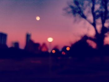 Defocused image of illuminated city against sky at night