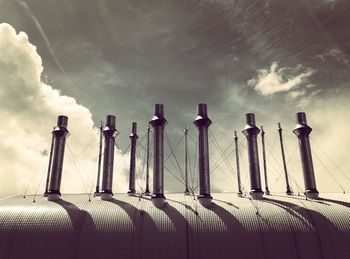 Low angle view of smoke stacks against sky