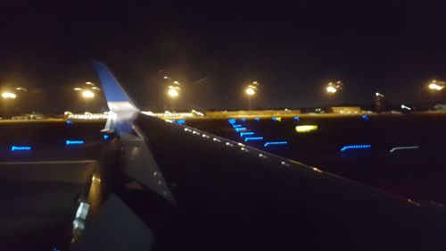 Light trails on road in city against sky at night