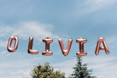 Low angle view of text against blue sky