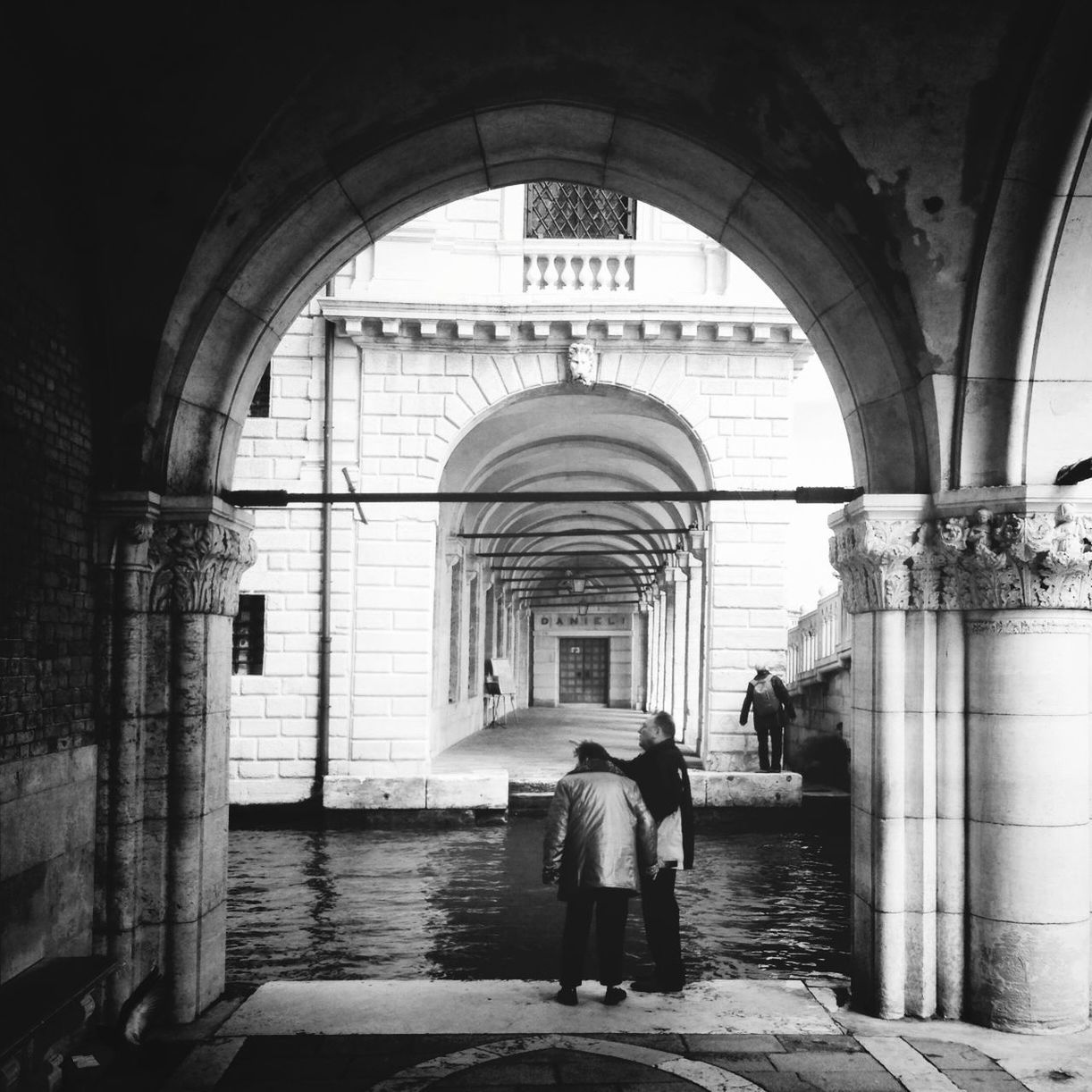 arch, architecture, built structure, full length, lifestyles, men, walking, person, rear view, indoors, building exterior, leisure activity, archway, entrance, casual clothing, standing, building