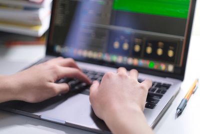 Midsection of man using laptop on table