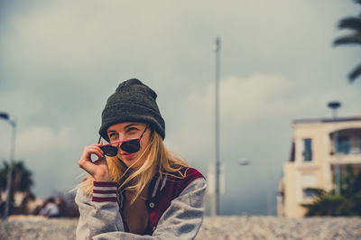 Woman photographing with mobile phone standing on snow