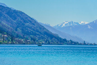 Scenic view of sea and mountains against clear sky
