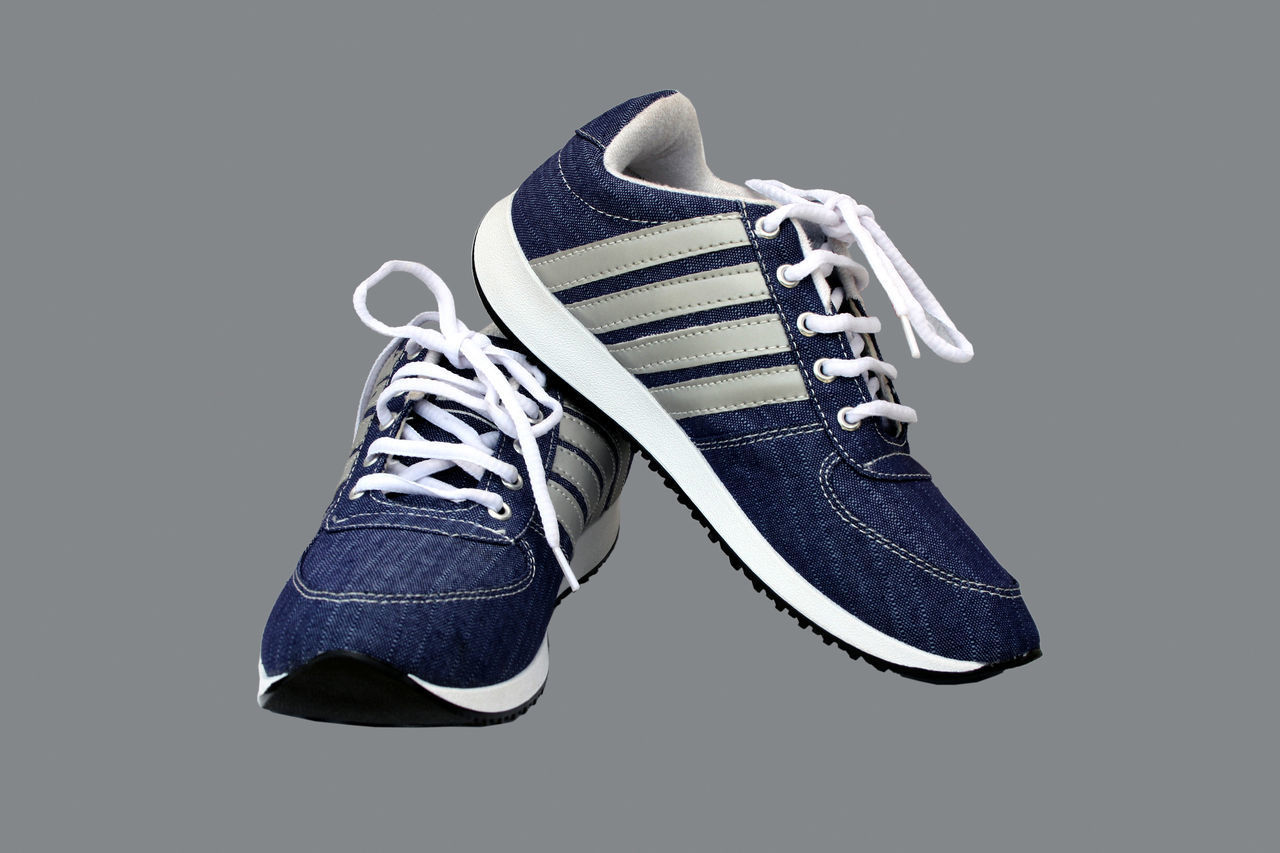 CLOSE-UP OF SHOES AGAINST BLUE BACKGROUND