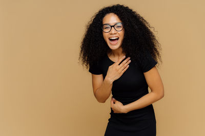 Portrait of a smiling young woman against gray background