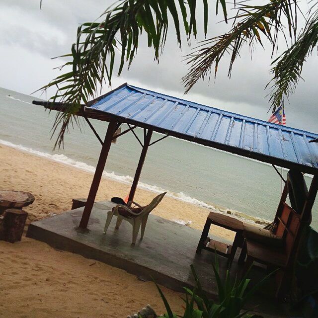 sea, water, beach, sky, horizon over water, shore, sand, nature, tranquility, day, tranquil scene, outdoors, built structure, absence, railing, beauty in nature, cloud - sky, nautical vessel, no people, scenics