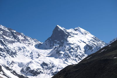 Scenic view of snowcapped mountains against blue sky