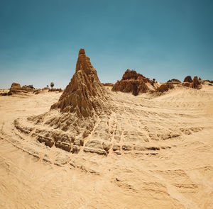 Iconic eroded sand rock formation with dramatic cloud formation in the sky