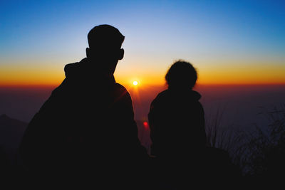 Silhouette people standing against sky during sunset