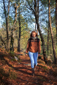 Rear view of woman standing in forest