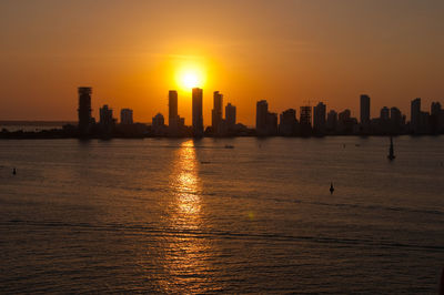 View of city at waterfront during sunset