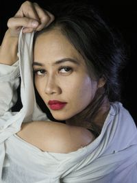 Portrait of a beautiful young woman over black background