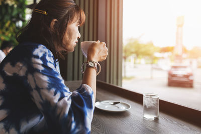 Side view of a woman drinking coffee