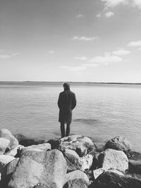 Rear view of man looking at sea against sky